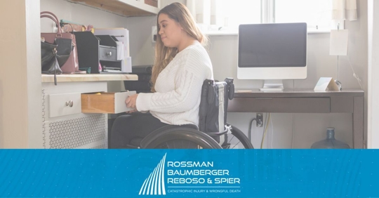 Woman in a wheelchair opening an office drawer.