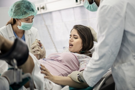 Woman in labor holding doctor's hand