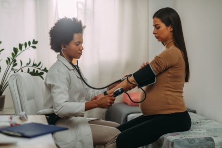 Pregnant woman having blood pressure checked