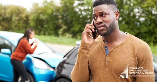 man on the phone beside a crash
