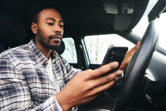 african american man texting while driving
