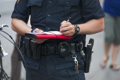 police officer writing traffic ticket for truck driver